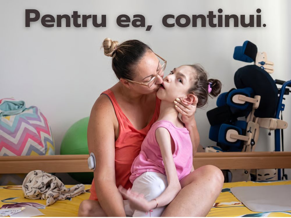 Mama Sofiei o ține în brațe și o sărută pe obraz